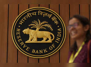 FILE PHOTO: A woman walks past the Reserve Bank of India (RBI) logo inside its headquarters in Mumbai
