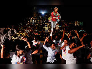 Fans of Tamil film star Rajinikanth dance inside a cinema hall during his film, Jailer, in Mumbai