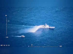 A Chinese Coast Guard ship launches what the Coast Guard says is a warning water cannon spray in the direction of a Philippine vessel at an unknown location at sea