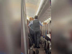 In this image from a video, a passenger, left, speaks with crew members during a...