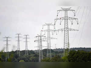 General view taken as workers of electricity transmission operator TransnetBW assemble a 380-KV power line on a high-voltage power pole near Pforzheim, southern Germany, on August 3, 2023.  TransnetBW operates the electricity transmission grid in Federal state Baden-Wuerttemberg and expands it with a new 12 kilometers long  high-voltage line near this city. (Photo by THOMAS KIENZLE / AFP)