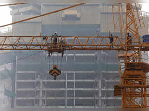 Construction workers are pictured on a crane at a construction site in Mumbai