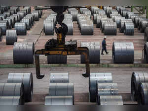 FILE PHOTO: Worker walks past steel rolls at the Chongqing Iron and Steel plant in Changshou