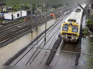 Mumbai: A train runs on a waterlogged railway track between Marine Lines and Chu...