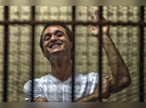 (FILES) Egyptian political activist Ahmed Douma reacts as he stands behind dock bars during his trial in Cairo on June 3, 2013, on charges of insulting president Mohamed Morsi. Douma was convicted to serve six months in prison. Egypt's president pardoned jailed activist Ahmed Douma, his lowyers said. (Photo by Khaled DESOUKI / AFP)