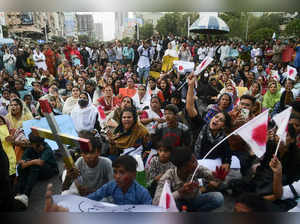 Christians wave flags as they hold the holy cross during a protest in Karachi on August 19, 2023, to condemn the attacks on churches in Pakistan. More than 80 Christian homes and 19 churches in Pakistan were vandalised when a Muslim mob rampaged through the streets over alleged blasphemy on August 16, a top police official said on August 18. (Photo by Asif HASSAN / AFP)