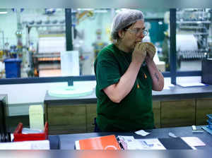 A Rizla+ employee tests the quality of the cigarette papers at the Rizla+ factory of cigarette papers in Anvers on July 6, 2023. As Europe steadily stubs out smoking in the name of public health, a storied French brand of cigarette rolling papers owned by a British group has turned its gaze to Asia. Rizla+ -- pronounced "Riz-Lacroix" -- is relying on Belgium's busy port of Antwerp to trampoline its Arabic-gummed papers to those markets on the other side of the planet. (Photo by Kenzo TRIBOUILLARD / AFP)