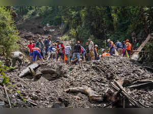 Shimla: Rescue workers remove the debris as they search for survivors after a la...