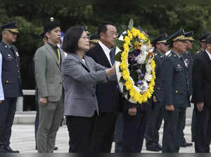 Taiwan's President Tsai Ing-wen carries the wreath during a ceremony commemorati...