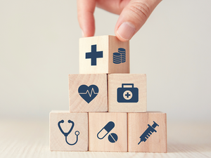 _0032_health-insurance-concept-reduce-medical-expenses-hand-flip-wood-cube-with-icon-healthcare-medical-coin-wood-backgr