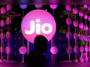 FILE PHOTO: A man walks across the LED board showing the logo of Jio at the ongoing India Mobile Congress 2022, at Pragati Maidan, in New Delhi