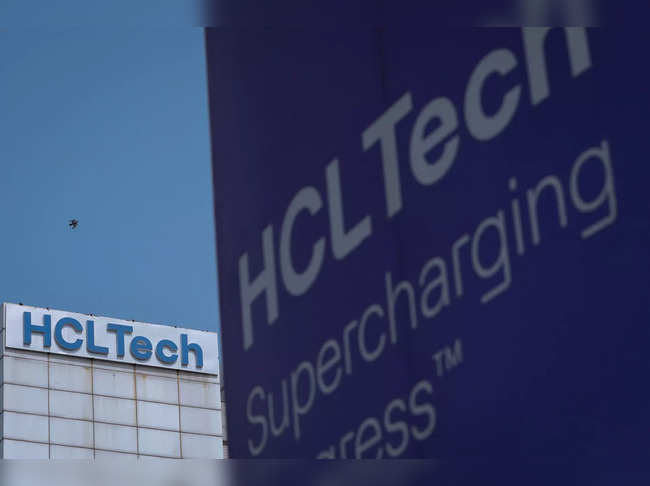 A pigeon flies past a logo of HCL Technologies installed at their headquarters in Noida