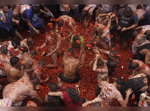 Revelers hurl tomatoes at each other and streets awash in red pulp in Spanish town's Tomatina party