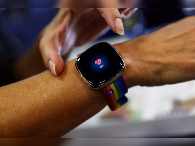 FILE PHOTO: An employee uses an electrocardiogram function on a Fitbit smartwatch at the IFA consumer technology fair, in Berlin