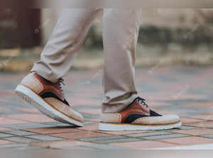 close-up-shot-man-wearing-sneakers-with-beige-classic-pants_665346-36637.