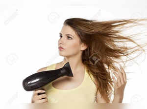 64303595-beautiful-young-woman-drying-her-hair-with-a-hair-dryer.