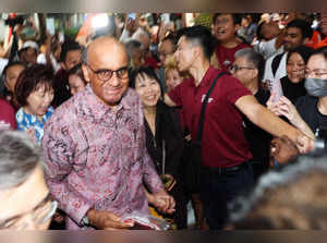 Presidential candidate Tharman Shanmugaratnam arrives with his wife Jane Ittogi to meet supporters during the presidential election in Singapore
