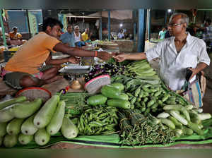 Nikhil Kumar Mondal buys vegetables from a vendor at a market on the outskirts of Kolkata