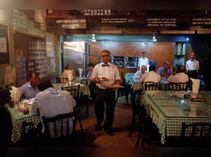 Waiter carries plates of food for customers at the Britannia and Co. restaurant in Mumbai