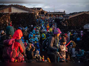 (FILES) People gather after watching the sunrise from the summit of Mount Fuji early on August 15, 2022, some 70 kilometres (43 miles) west of the capital Tokyo. Japanese authorities are gearing up to impose crowd control measures for the first time on Mount Fuji this weekend for an expected holiday rush by thousands of sometimes ill-prepared trekkers, officials said on August 10, 2023. (Photo by Philip FONG / AFP)