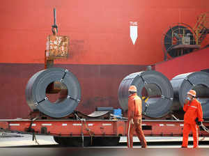 Workers load steel products for export to a cargo ship at a port in Lianyungang
