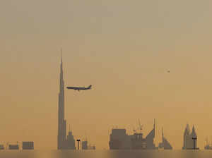 (FILES) A commercial airplane flies past Burj Khalifa as it starts landing at Dubai international airport in the United Arab Emirates, on January 9, 2021. Passenger traffic at Dubai international airport leapt 50 percent in the first half of the year, surpassing pre-pandemic levels, its operator said on August 22, 2023. (Photo by GIUSEPPE CACACE and GIUSEPPE CACACE / AFP)