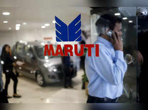 FILE PHOTO: A man speaks on his mobile phone as he exits a glass door with the logo of  Maruti Suzuki India Limited at a showroom in New Delhi,