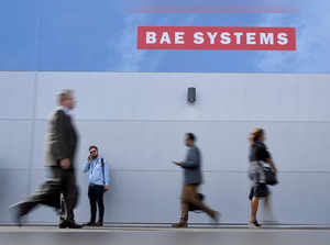 FILE PHOTO: Trade visitors walk past an advertisement for BAE Systems at Farnborough International Airshow in Farnborough, Britain