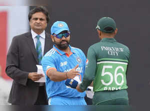 India's captain Rohit Sharma, in blue, shakes hands with his Pakistani counterpa...