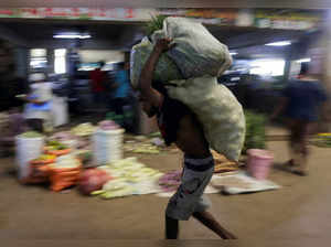 FILE PHOTO: A worker carries sacks of vegetables at a wholesale market in Colombo, Sri Lanka