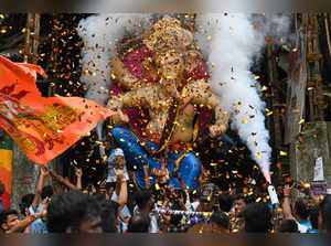 Devotees carry an idol of the elephant-headed Hindu deity 'Ganesha' during a procession along a street in Mumbai on September 17, 2023, ahead of the Ganesh Chaturthi festival.