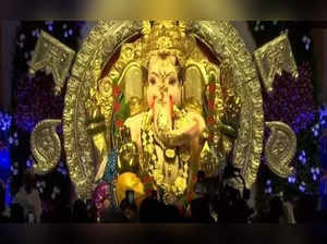 ​Lord Ganesha adorned with gold & silver.