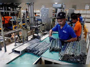Employees collect drawer slides on an assembly line inside Hettich furniture fittings, manufacturing facility in Vadodara
