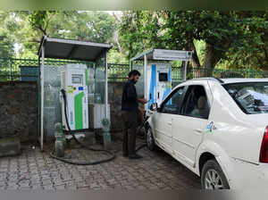 FILE PHOTO: A man plugs an electric car at a charging station in New Delhi
