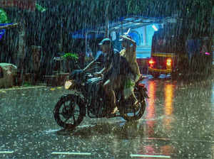 Thiruvananthapuram: A two-wheeler rider amid rains, in Thiruvananthapuram. (PTI ...