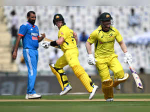 Australia's Steve Smith (C) and David Warner (R) run between the wickets during the first one-day international (ODI) cricket match between India and Australia at Punjab Cricket Association Stadium in Mohali on September 22, 2023.