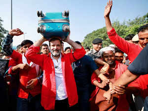 Congress leader Rahul Gandhi carries luggage on his hea...