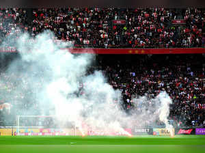 This photograph taken on September 24, 2023, shows smoke rising from fireworks thrown on the field by Ajax' supporters during the Dutch Eredivisie football match between Ajax Amsterdam and Feyenoord at the Johan Cruijff Arena in Amsterdam.
