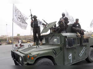 Taliban fighters patrol on the road during a celebration marking the second anni...