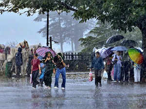 Shimla: People amid monsoon rainfall at The Ridge, in Shimla. (PTI Photo)(...