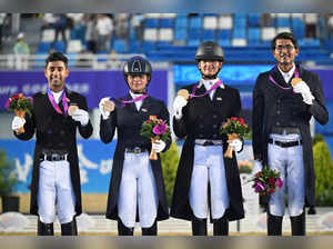 Gold medalists Sudipti Hajela, Divyakriti Singh, Vipul Chheda Hriday and Anush Agarwalla of India pose for picture on the podium during the medal ceremony of the Prix St-Georges of Equestrian Dressage team event during the Hangzhou 2022 Asian Games in Hangzhou, in China's eastern Zhejiang province on September 26, 2023.