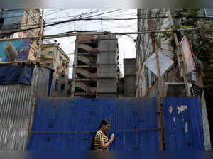 A woman walks past an under construction residential house in Kolkata