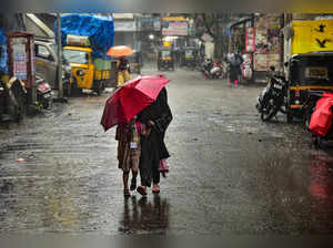 Navi Mumbai: Pedestrians during rainfall, at Kopar Khairane in Navi Mumbai. (PTI...