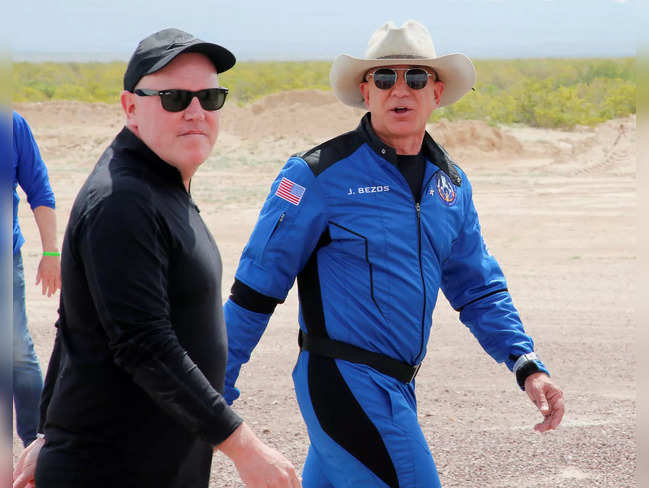Billionaire American businessman Jeff Bezos walks with Blue Origin's President and CEO Bob Smith after Bezos flew on the company's inaugural flight to the edge of space, in the nearby town of Van Horn