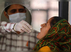 Jammu: A healthcare worker collects a swab sample of a woman for Covid-19 test, ...