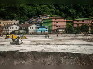 People walk along the area affected by flood at Golitar, in Singtam