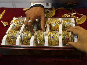 FILE PHOTO: A salesman helps a customer to select gold bangles at a jewelry showroom in Mumbai