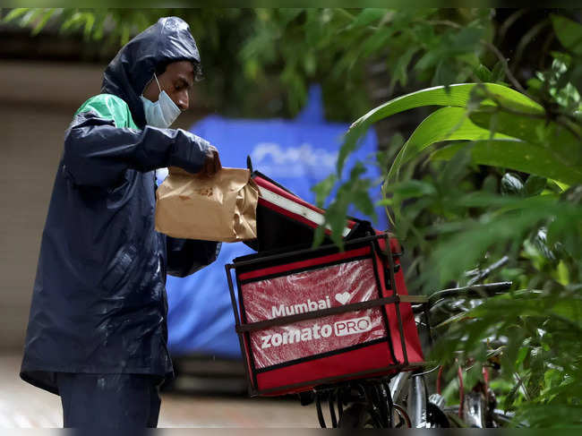 A delivery worker of Zomato picks a food package in Mumbai