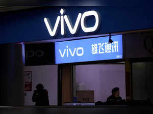 A man walks by a VIVO logo at a shopping mall in Shanghai