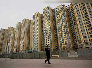 A man walks past a housing complex by Chinese property developer Evergrande in Beijing on December 8, 2021.